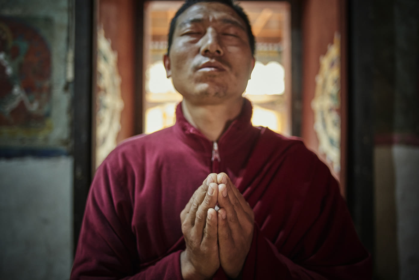 A monk and prayer flags above the Phobjikha Valley near Six Senses Gangtey