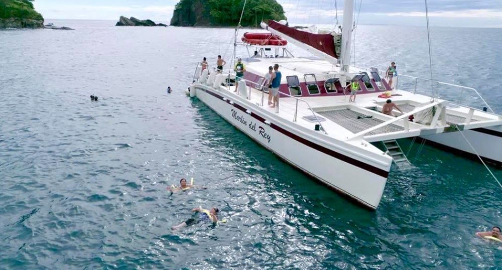 A catamaran in a turquoise cove off Playas del Coco