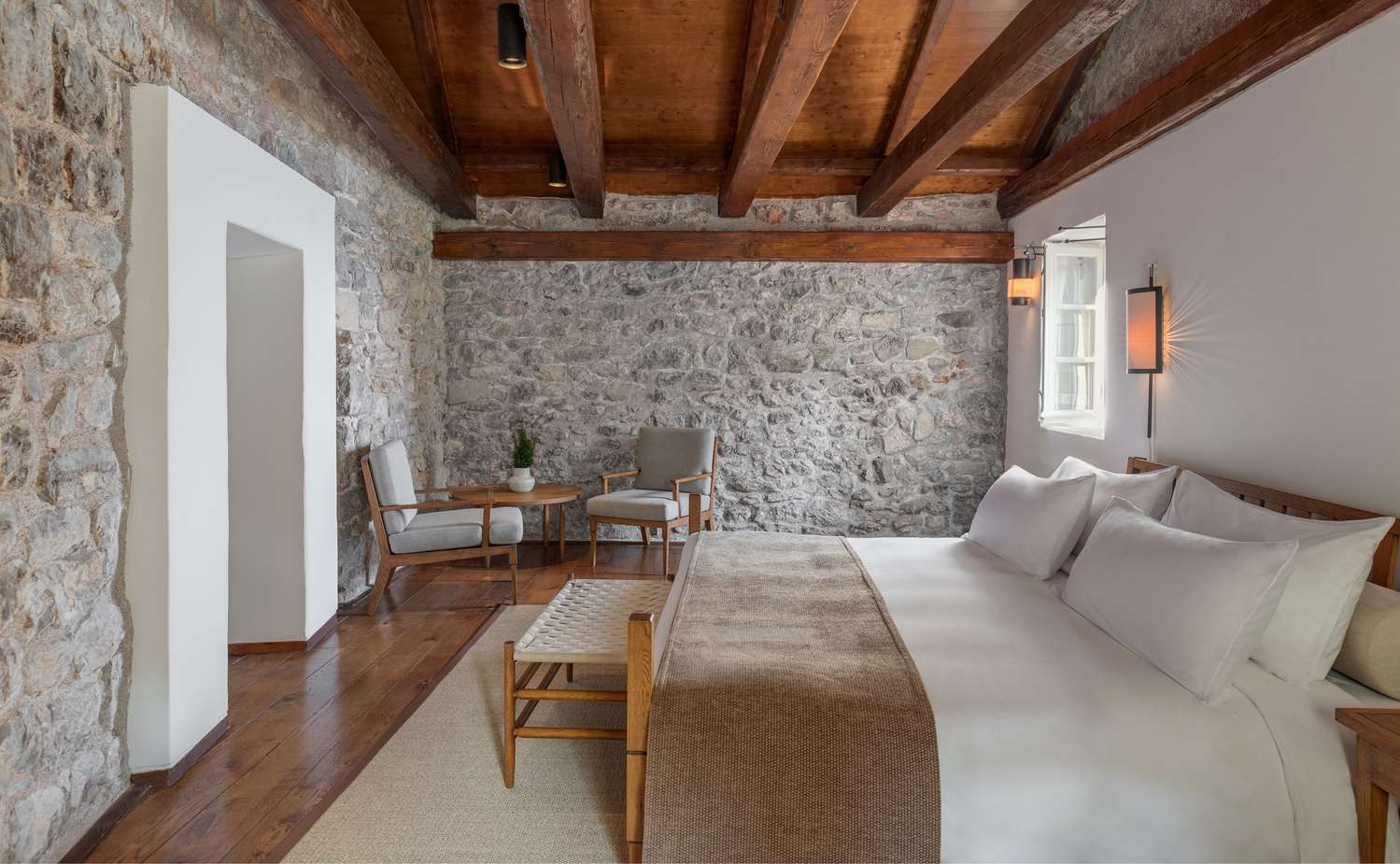 A stone-walled bedroom at Aman Sveti Stefan