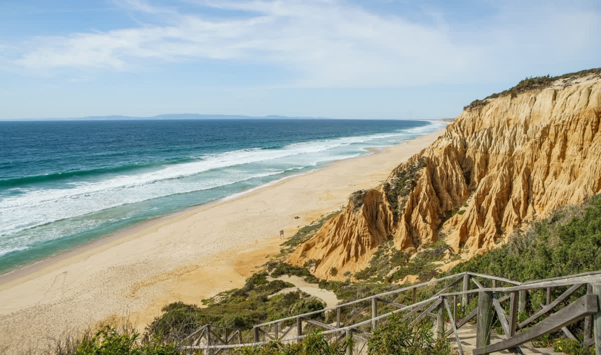 The wild Atlantic beach and golden cliffs of the Melides coast on the Alentejo
