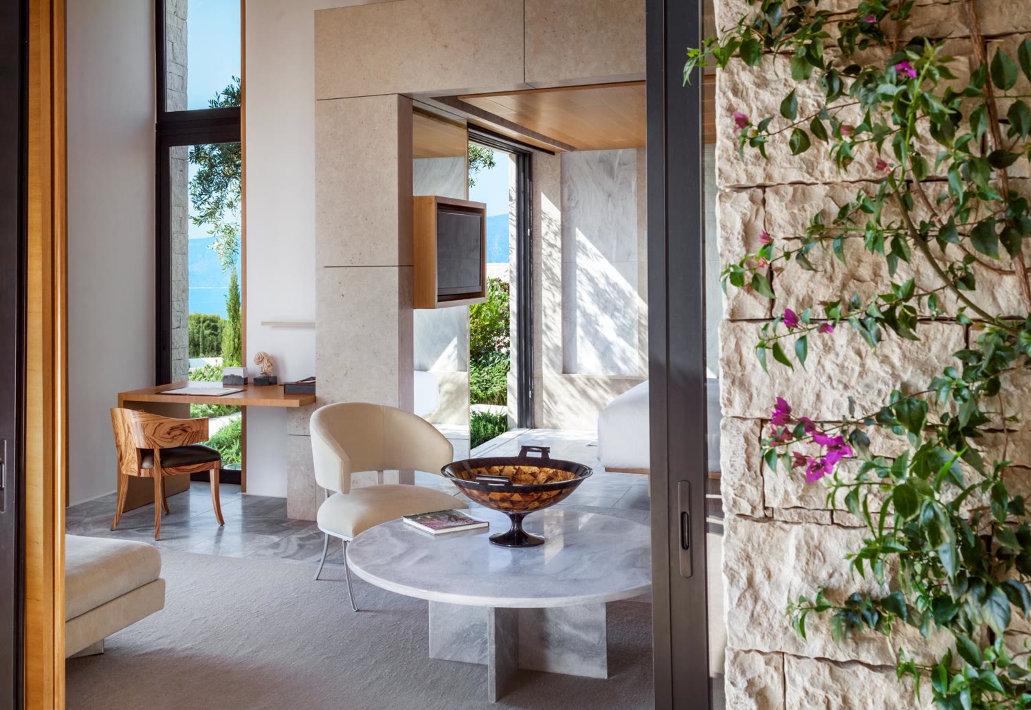 A pavilion sitting area with bougainvillea and a sea view at Amanzoe