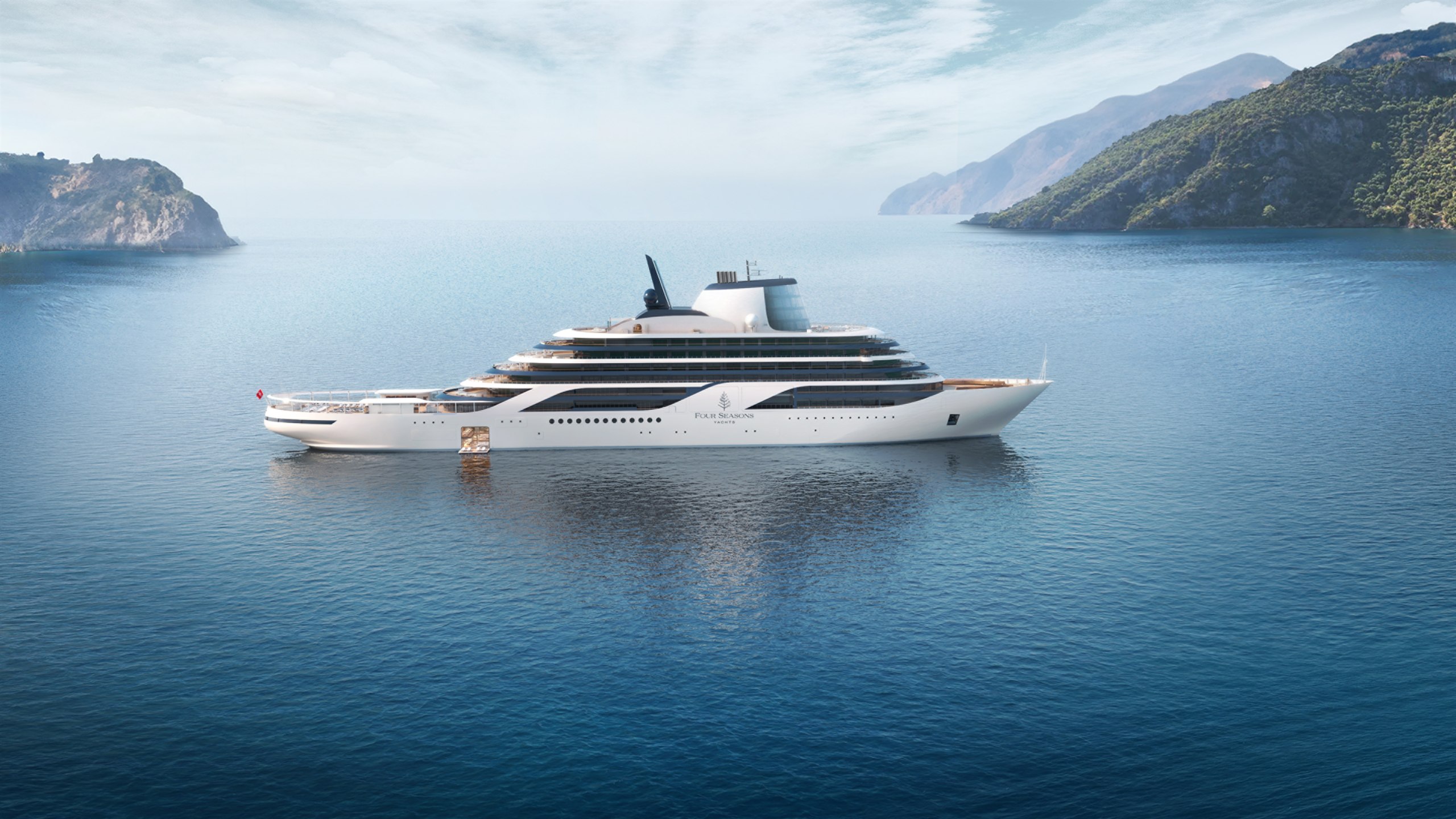 Four Seasons I, the brand's first purpose-built yacht, at anchor between two headlands