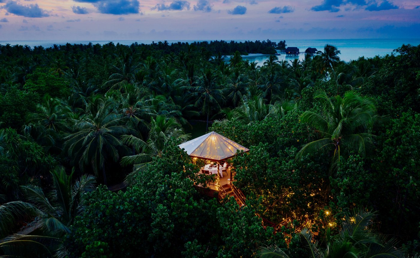One&Only Reethi Rah aerial view of illuminated treetop dining pavilion on a private Maldivian island