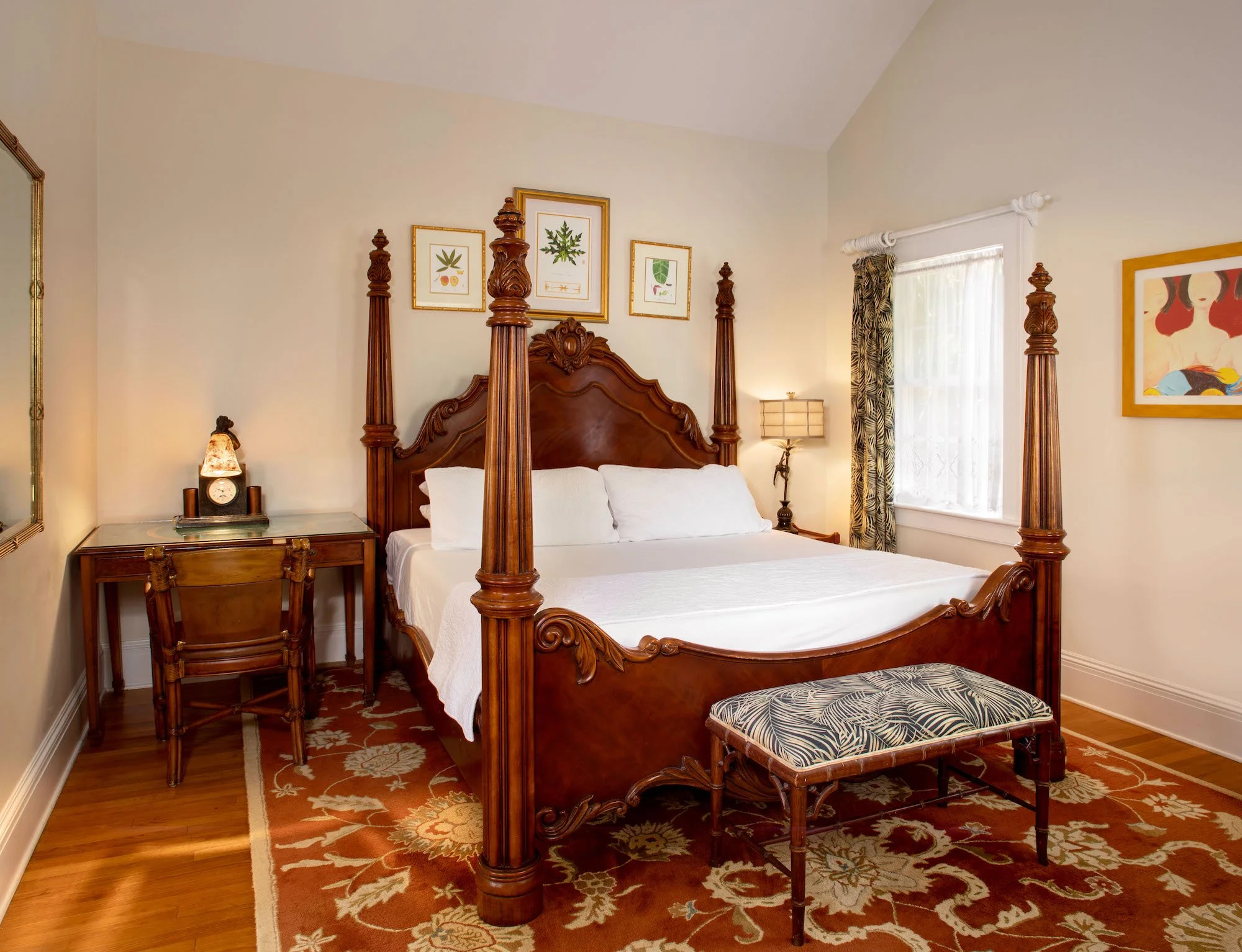 A garden-view king room with a carved four-poster bed at The Gardens Hotel, Key West
