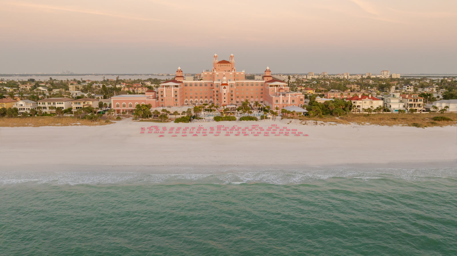 Aerial of The Don CeSar, the pink palace, on the white-sand beach and the Gulf at sunset