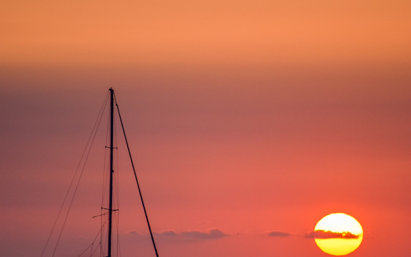 A sailing yacht silhouetted against the sunset on the Gulf of Mexico
